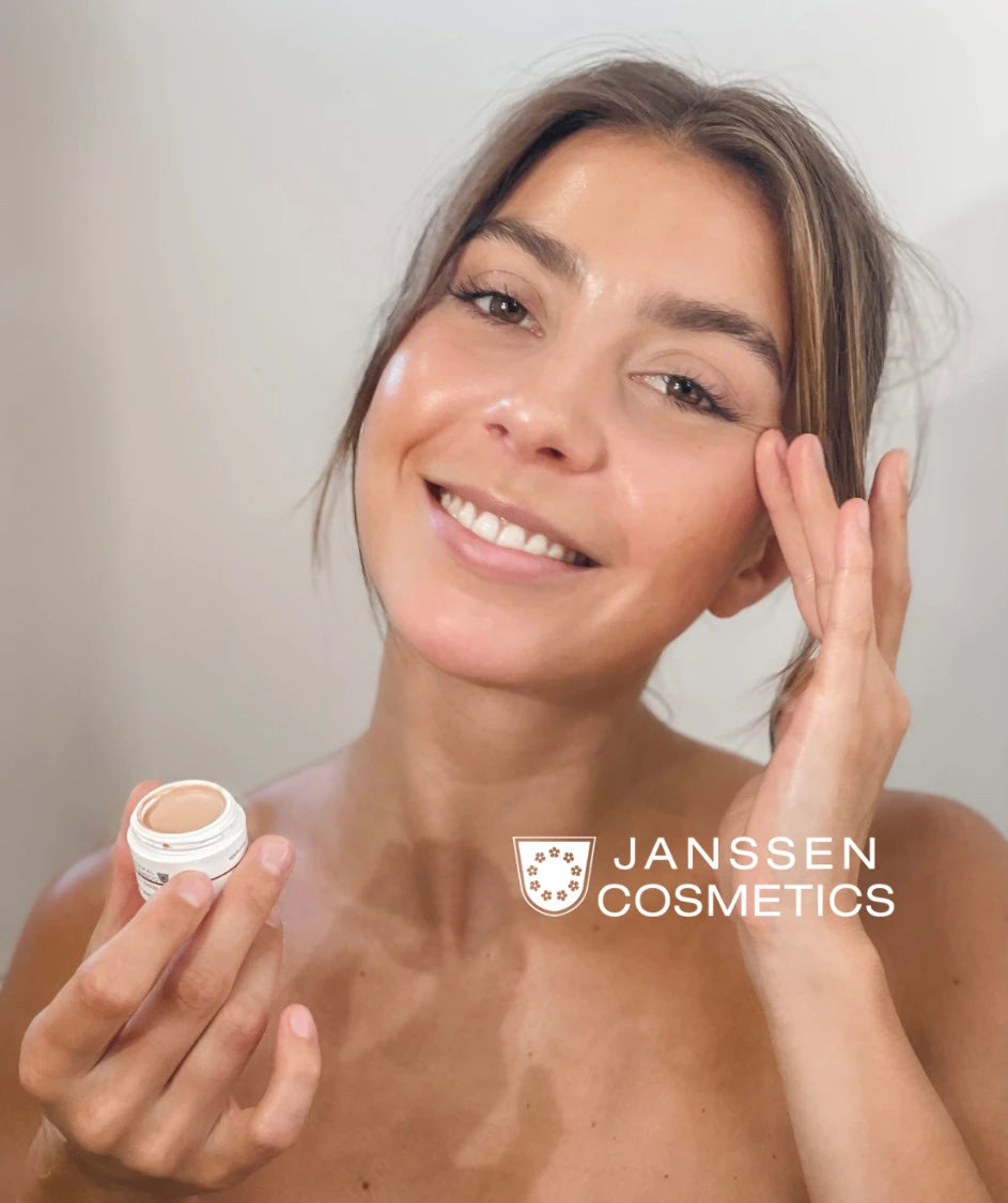 Donna sorridente che applica una crema Janssen Cosmetics sul viso